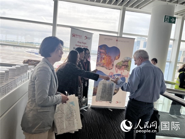 圖為工作人員向乘客發(fā)放復(fù)航首班禮物。 牛瑞飛攝