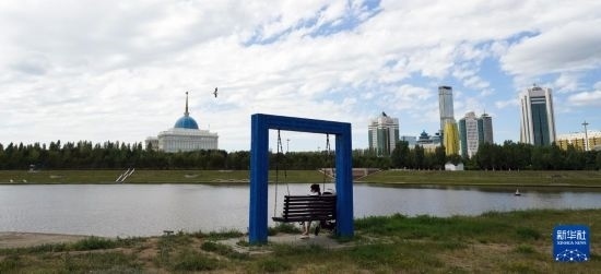 6月30日，一名女子在哈薩克斯坦首都阿斯塔納伊希姆河畔休息。新華社記者 王建華 攝