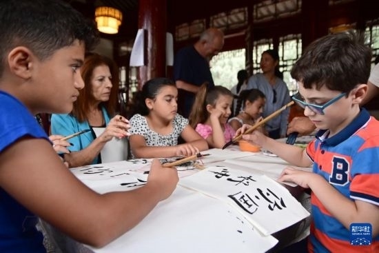 7月4日，在馬耳他桑塔露琪亞市的中國古典園林“靜園”，人們體驗中國書法。新華社發(fā)（喬納森·博格 攝）