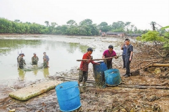 圖②：執(zhí)行干警督促凌某捕魚(yú)清塘。