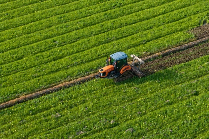 2024年3月19日，在湖南省常德市鼎城區(qū)謝家鋪鎮(zhèn)港中坪村，村民駕駛農(nóng)機(jī)翻耕田地（無人機(jī)照片）。新華社記者 陳思汗 攝