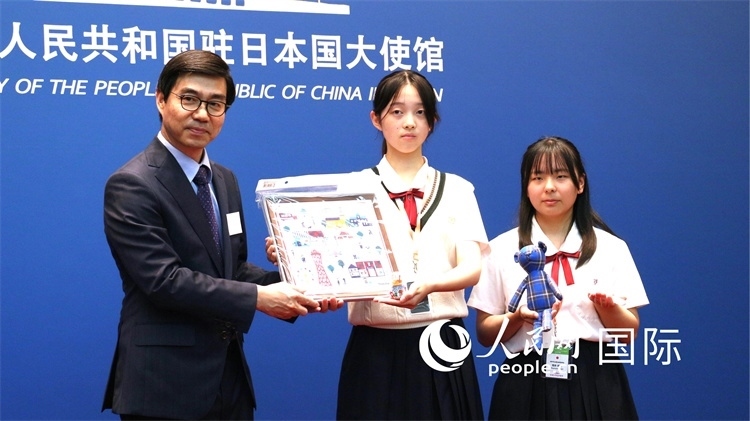 日本小大使向中國駐日本大使館臨時代辦施泳贈送當地特色禮品。人民網 許可攝