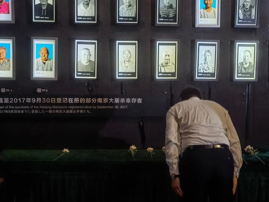 7月18日，人們向離世的南京大屠殺幸存者獻花、鞠躬。新華社記者邱冰清 攝