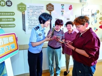 浙江湖州民警指導(dǎo)居民加入湖州“e企安”微信群，實(shí)時(shí)接收反詐信息。新華社發(fā)