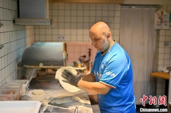 近日，韋榮耀在自家披薩小店內(nèi)忙活。俞靖 攝