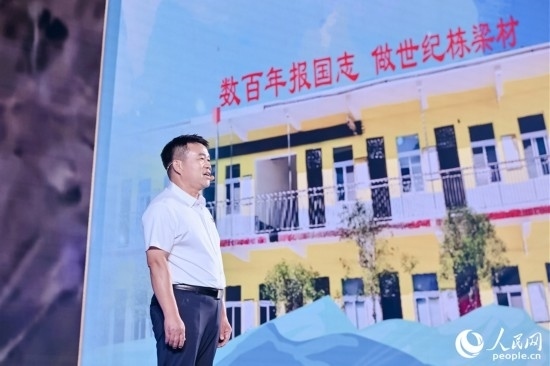 張玉滾分享用一根扁擔(dān)送孩子們走出大山的故事。人民網(wǎng)攝