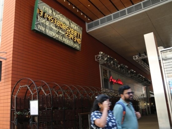 2023年5月29日，人們經(jīng)過美國紐約曼哈頓的“國債鐘”?！皣鴤姟笔且粋€大型計數(shù)器，它實時更新美國的公共債務總額，并顯示出每個美國家庭所要負擔的數(shù)額。 新華社記者劉亞南攝