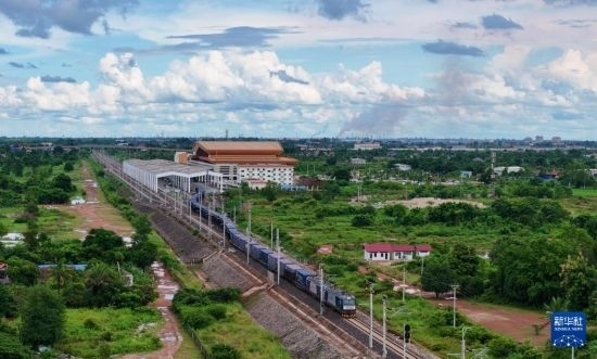 8月5日，由老撾籍火車司機(jī)獨(dú)立駕駛的滿載貨物的列車駛出萬象站，向中國昆明進(jìn)發(fā)（無人機(jī)照片）。新華社發(fā)（楊永全 攝）
