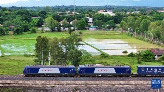8月5日，由老撾籍火車司機(jī)獨(dú)立駕駛的滿載貨物的列車駛出萬象站，向中國昆明進(jìn)發(fā)（無人機(jī)照片）。新華社發(fā)（楊永全 攝）