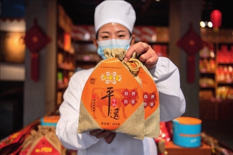 在位于山西省晉中市平遙縣的平遙古城南大街的一家平遙牛肉店內(nèi)，工作人員展示一款牛肉產(chǎn)品（資料照片）楊晨光攝 / 本刊