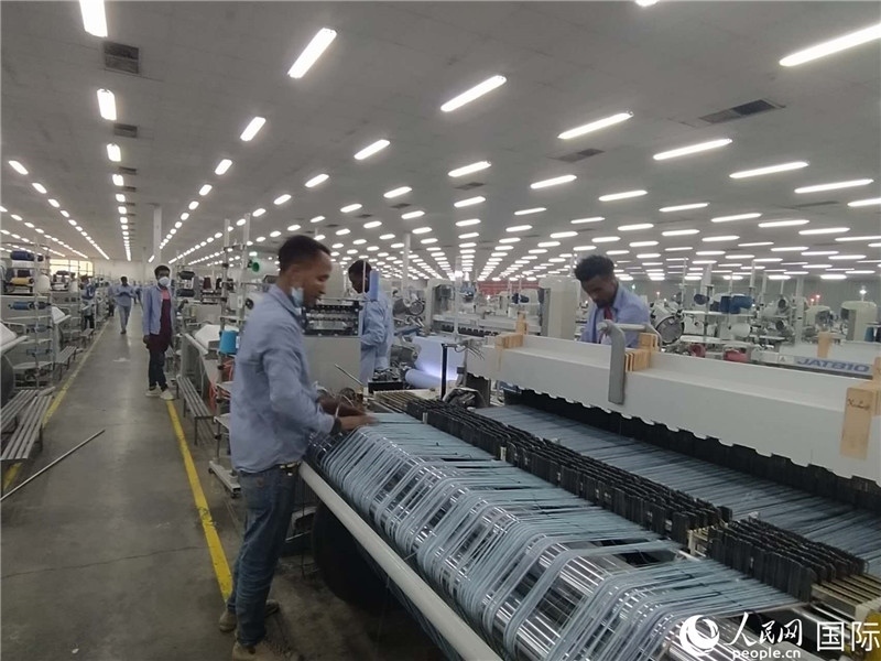 無錫金茂埃塞面料廠車間內(nèi)，當(dāng)?shù)毓と苏谝唤z不茍地作業(yè)。人民網(wǎng)記者 黃培昭攝
