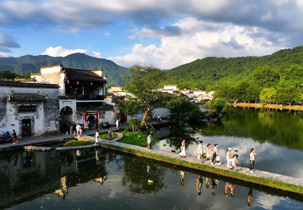 2024年7月7日，游客在安徽省黃山市黟縣宏村游玩。新華社記者杜宇攝