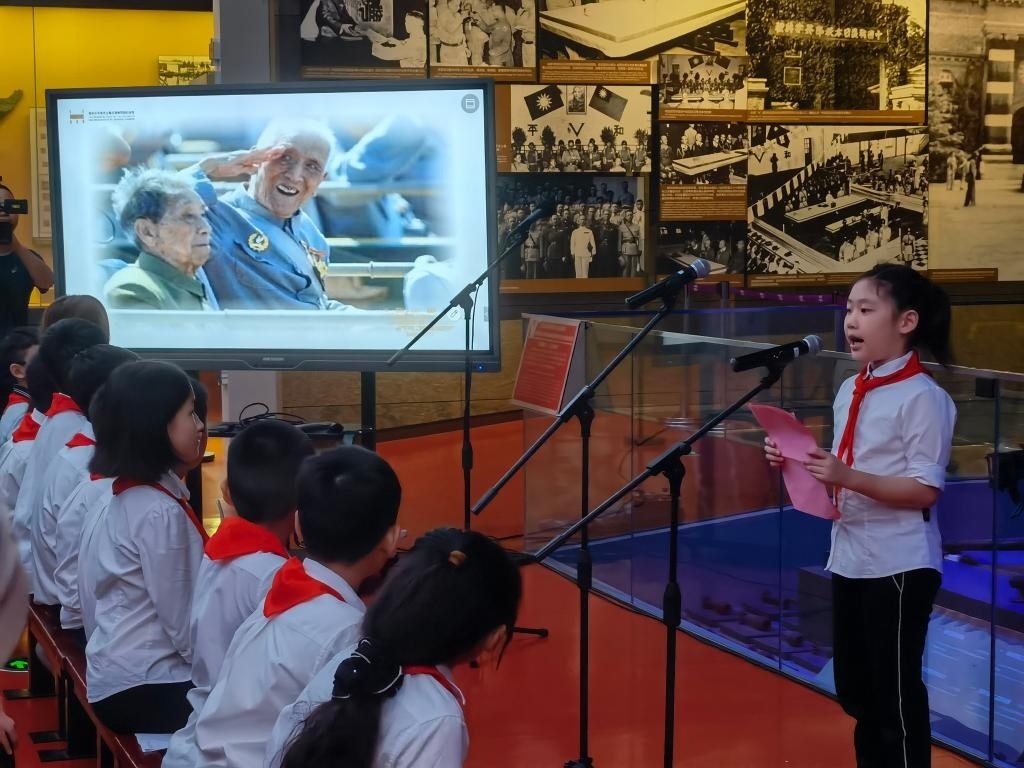 南京市科睿小學(xué)二年級學(xué)生章若初為大家講述抗戰(zhàn)老兵手印的故事。 新華社記者 邱冰清 攝
