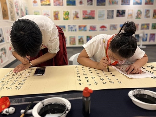 參加本次展覽的青少年在現(xiàn)場進行書法創(chuàng)作。主辦方供圖