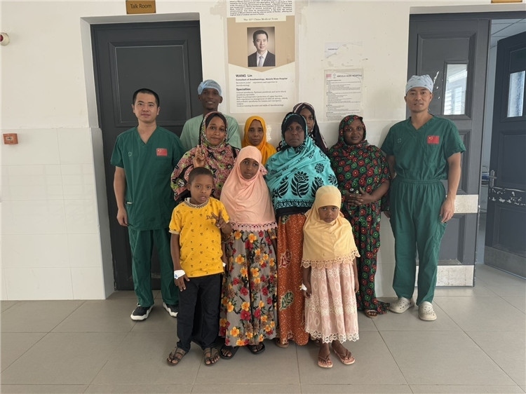 李廣（右一）和王林醫(yī)生與部分患者合影。中國援桑醫(yī)療隊供圖