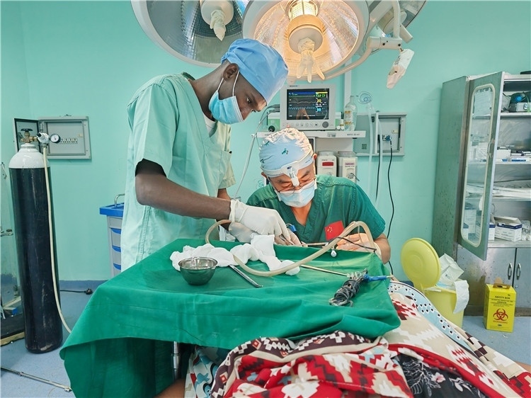 李廣醫(yī)生與當地醫(yī)生在做手術中。中國援桑醫(yī)療隊供圖