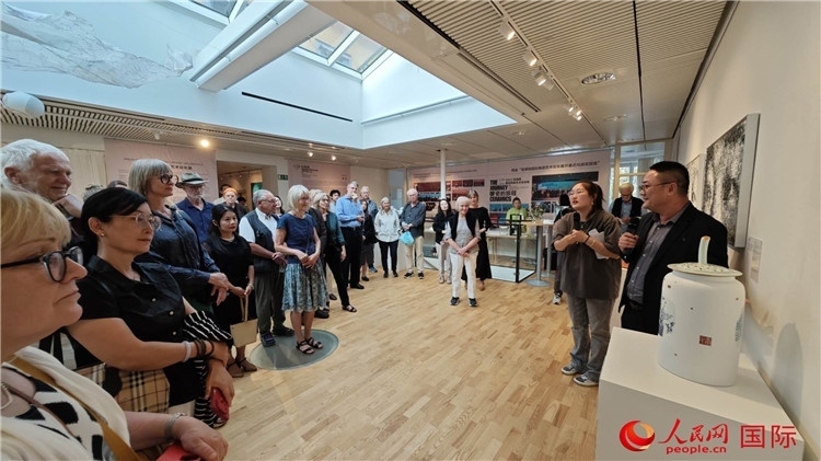 參展人、景德鎮(zhèn)陶瓷大學(xué)美術(shù)學(xué)院副院長(zhǎng)邵長(zhǎng)宗（右一）向來(lái)賓介紹參展作品。人民網(wǎng)記者 殷淼攝