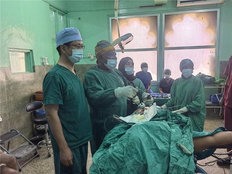 隊(duì)長(zhǎng)蔣國(guó)慶（左一）關(guān)注當(dāng)?shù)蒯t(yī)生手術(shù)情況。中國(guó)援桑醫(yī)療隊(duì)供圖