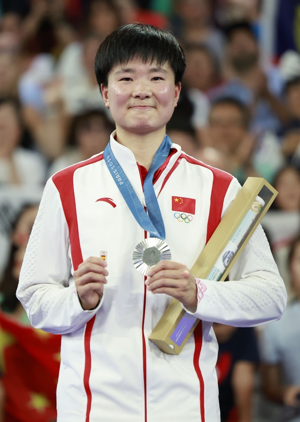 巴黎奧運會羽毛球女子單打亞軍、中國選手何冰嬌在頒獎儀式上一手握著銀牌，一手握著西班牙奧委會徽章（2024年8月5日攝）。新華社記者 任正來 攝