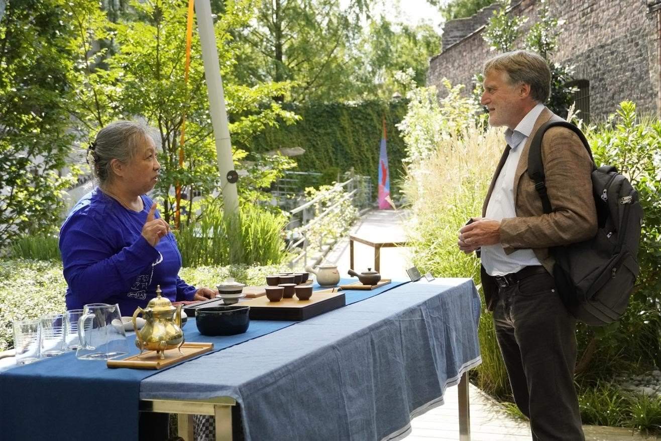 在博物館的戶外花園來賓品味中國茶藝。比利時維他命文化傳媒供圖