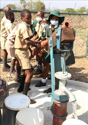 △2021年11月，在津巴布韋南馬塔貝萊蘭省省會關(guān)達(dá)的塞農(nóng)多小學(xué)，學(xué)生從中國援建水井里打水。