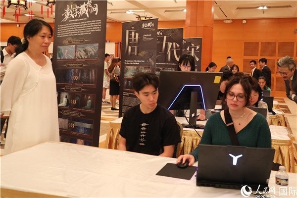 在活動(dòng)現(xiàn)場(chǎng)，當(dāng)?shù)孛癖婓w驗(yàn)“數(shù)字藏經(jīng)洞”云游戲，沉浸式體驗(yàn)敦煌文化。 人民網(wǎng)記者 李志偉攝