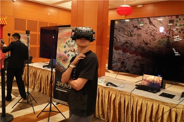 1、在本次活動(dòng)的展覽現(xiàn)場(chǎng)，敦煌研究院與騰訊展示了“數(shù)字藏經(jīng)洞”和“尋境敦煌”等創(chuàng)新互動(dòng)產(chǎn)品。圖為當(dāng)?shù)孛癖娡ㄟ^VR虛擬游覽洞窟。 人民網(wǎng)記者 李志偉攝