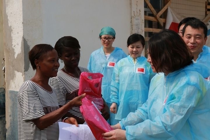 2015年4月4日，在位于塞拉利昂首都弗里敦市郊的中塞友好醫(yī)院埃博拉診療中心，中國第四批援塞醫(yī)療隊副隊長邵蔚（右前）向被治愈的埃博拉出血熱患者贈送禮物。新華社發(fā)（祖榮強(qiáng) 攝）