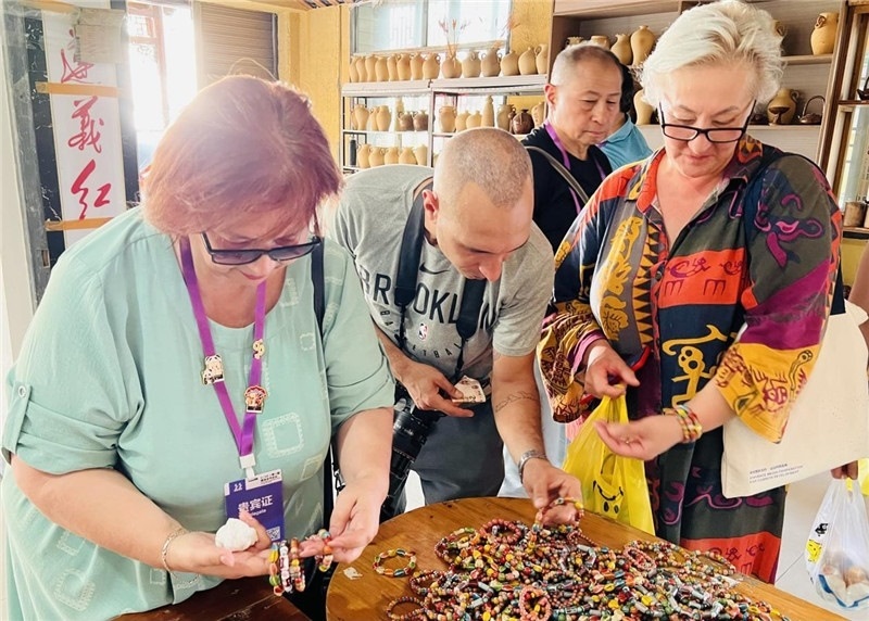 歐亞媒體考察團(tuán)成員在母氏陶藝館內(nèi)挑花了眼，色彩絢麗、質(zhì)地均勻的陶藝手串讓他們愛(ài)不釋手?！斑@里的東西都太實(shí)惠了！”塔吉克斯坦《索格特真理報(bào)》政論部主任娜塔利婭·多羅費(fèi)耶娃說(shuō)?；宓奶厣a(chǎn)品物美價(jià)廉，讓考察團(tuán)成員為家人好友買(mǎi)到了心儀的禮物，也為此次以四川成都為起點(diǎn)，路經(jīng)南充、廣安至貴州遵義的考察行程畫(huà)上了圓滿(mǎn)句號(hào)。（張亞欣攝）