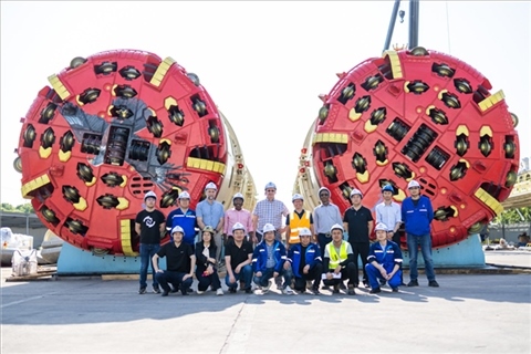 中外員工在盾構(gòu)機前合影。中國電建供圖