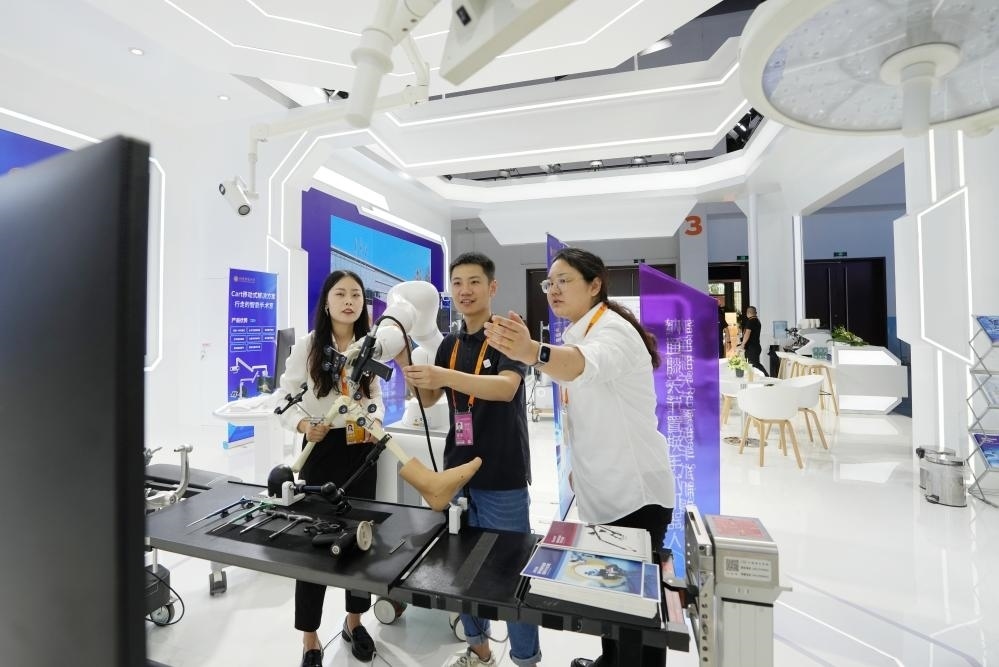 9月11日，一位媒體記者（中）在2024年服貿(mào)會(huì)國(guó)家會(huì)議中心會(huì)場(chǎng)體驗(yàn)北京納通科技集團(tuán)有限公司的膝關(guān)節(jié)置換手術(shù)機(jī)器人。新華社記者鞠煥宗 攝