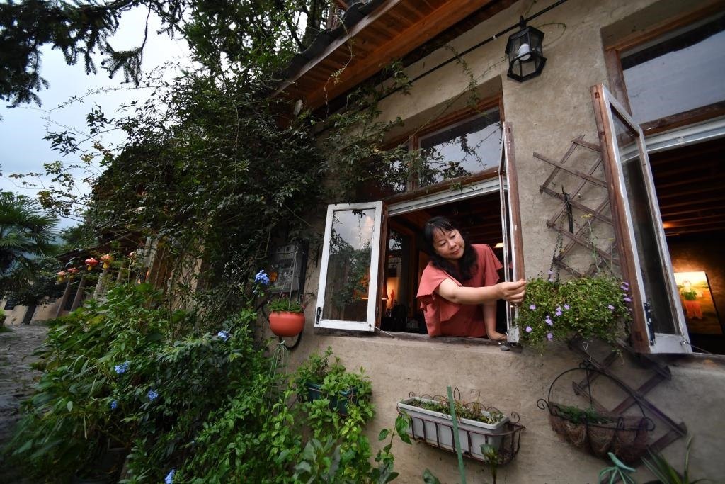 8月29日，在福建省屏南縣熙嶺鄉(xiāng)，龍?zhí)洞濉靶麓迕瘛泵泛暝诖蚶碜约航?jīng)營的民宿外墻裝飾花盆。新華社記者姜克紅 攝