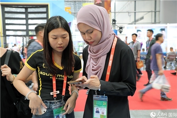 東博會現(xiàn)場，馬來西亞展商在同中方工作人員交談。人民網(wǎng)記者 趙益普攝