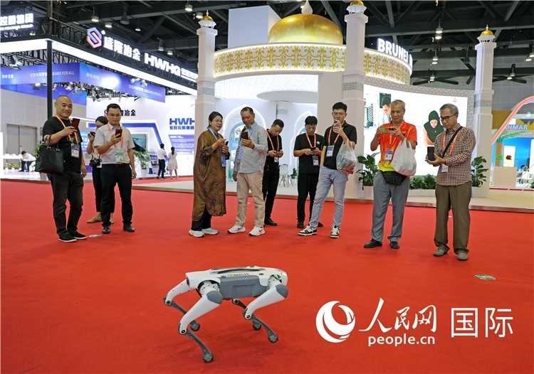 東博會(huì)上，觀眾正在參觀一只機(jī)器狗。綠色能源、新能源汽車、綠色農(nóng)產(chǎn)品等成為本屆東博會(huì)觀眾關(guān)注的焦點(diǎn)。人民網(wǎng)記者 趙益普攝