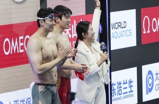  10月18日，汪順（左）和潘展樂在男子100米混合泳決賽后。新華社記者 方喆 攝