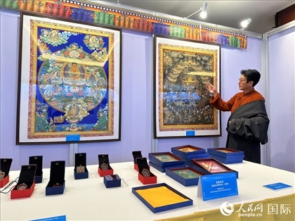 熱貢藝術(shù)國家級代表性傳承人夏吾角向嘉賓介紹作品。人民網(wǎng)記者 簡承淵攝