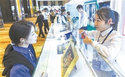 在北京麗澤商務(wù)區(qū)，工作人員（右一）介紹數(shù)字人民幣SIM卡硬錢包。新京報(bào)記者 陶冉攝