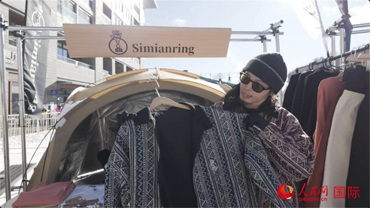 藤田周正在展示自己設(shè)計(jì)的滑雪服。人民網(wǎng)記者 袁蒙攝