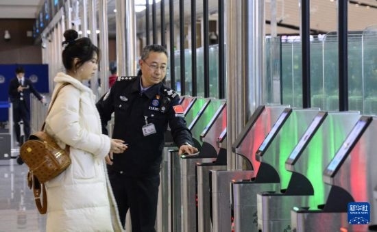 1月2日，大興機(jī)場(chǎng)邊檢站警察指導(dǎo)旅客使用自助出境設(shè)備。新華社記者 李欣 攝