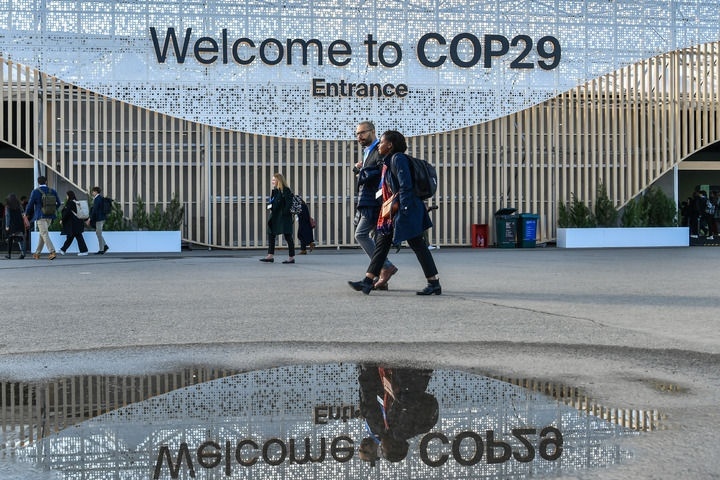 2024年11月15日，在阿塞拜疆首都巴庫(kù)，人們經(jīng)過聯(lián)合國(guó)氣候變化巴庫(kù)大會(huì)的會(huì)場(chǎng)。新華社記者 曹陽(yáng) 攝