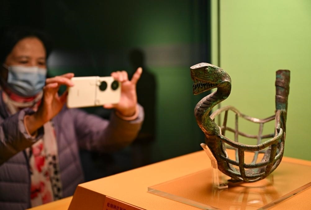 1月14日，觀眾在上海博物館蛇年迎春展拍攝展品蛇綱網(wǎng)狀銅器。新華社發(fā)（陳浩明攝）