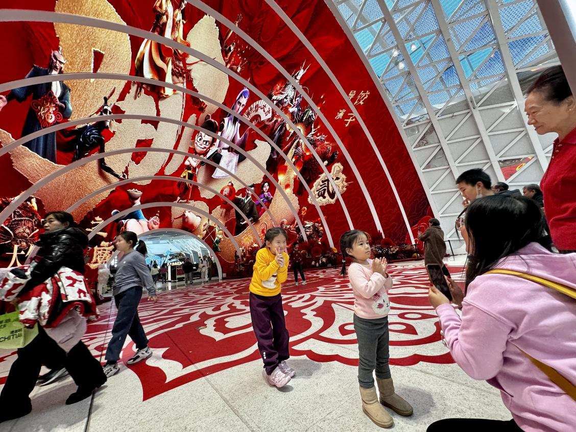 乙巳蛇年春節(jié)期間，影迷在《哪吒之魔童鬧?！肪薹?bào)前拍照打卡。