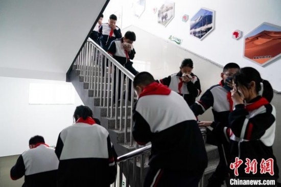  圖為學(xué)生們進(jìn)行應(yīng)急疏散演練。中新社記者 趙宇航 攝