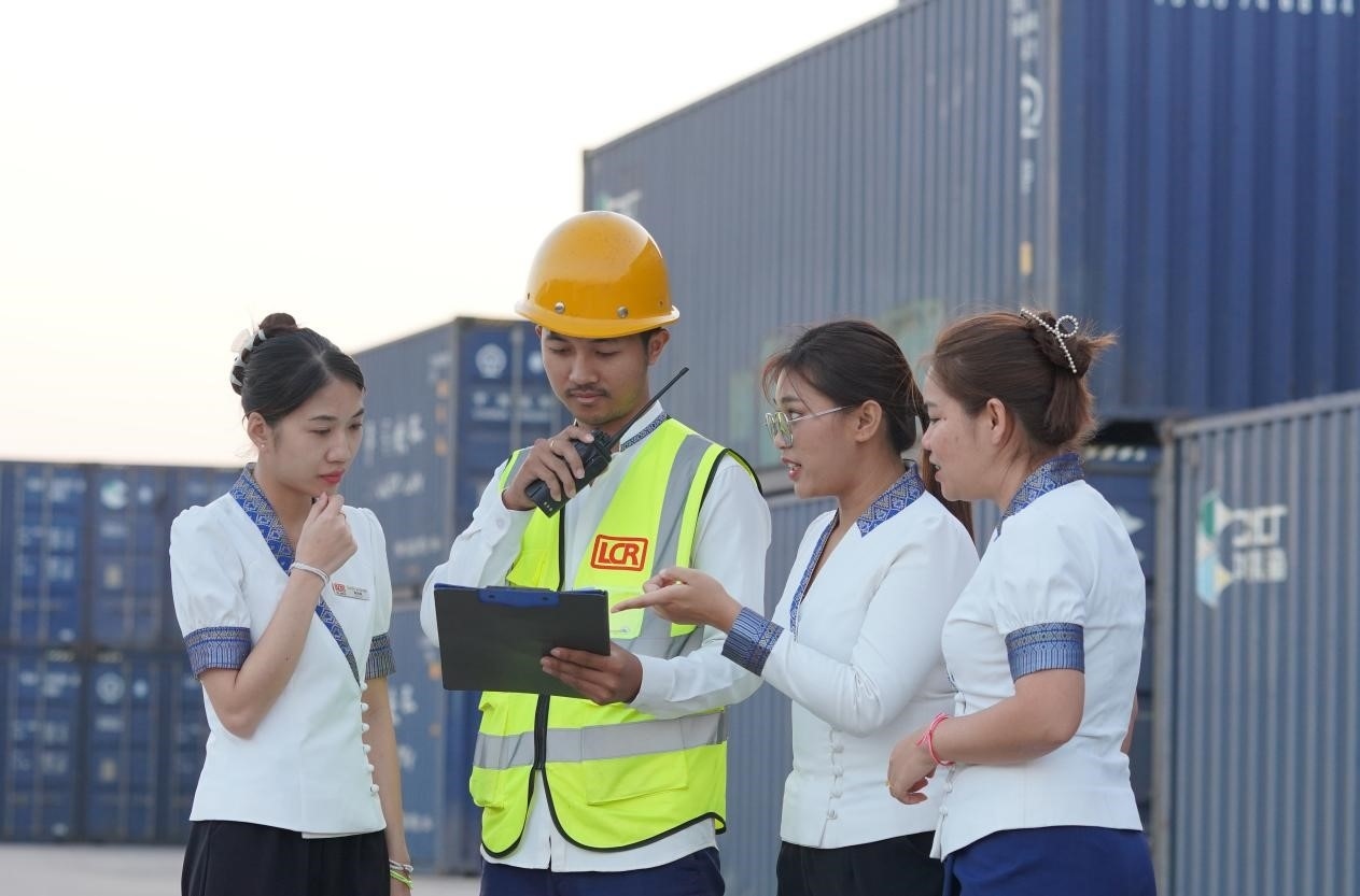 萬(wàn)象南站貨運(yùn)值班員陳尼啦（左一）與同事在一起討論工作。老中鐵路有限公司供圖