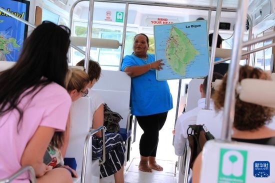 3月15日，一名導(dǎo)游在游艇上為游客介紹塞舌爾拉迪格島。新華社記者 董江輝 攝