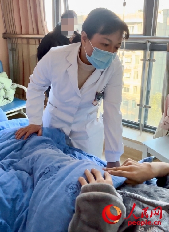 鄧茜查房時(shí)詢問患者情況。人民網(wǎng)記者 金慧慧攝