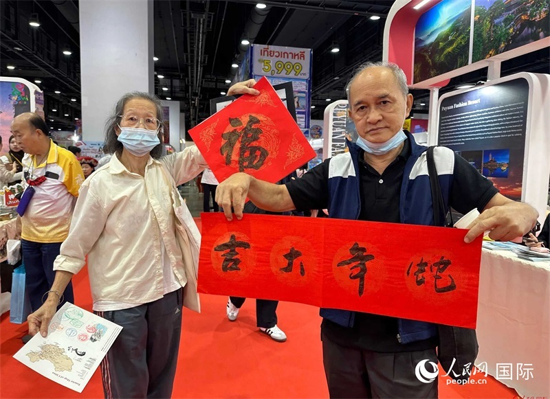 2025蛇年春節(jié)，泰國市民展示他們領(lǐng)到的華人手寫春聯(lián)。人民網(wǎng)記者 簡承淵攝