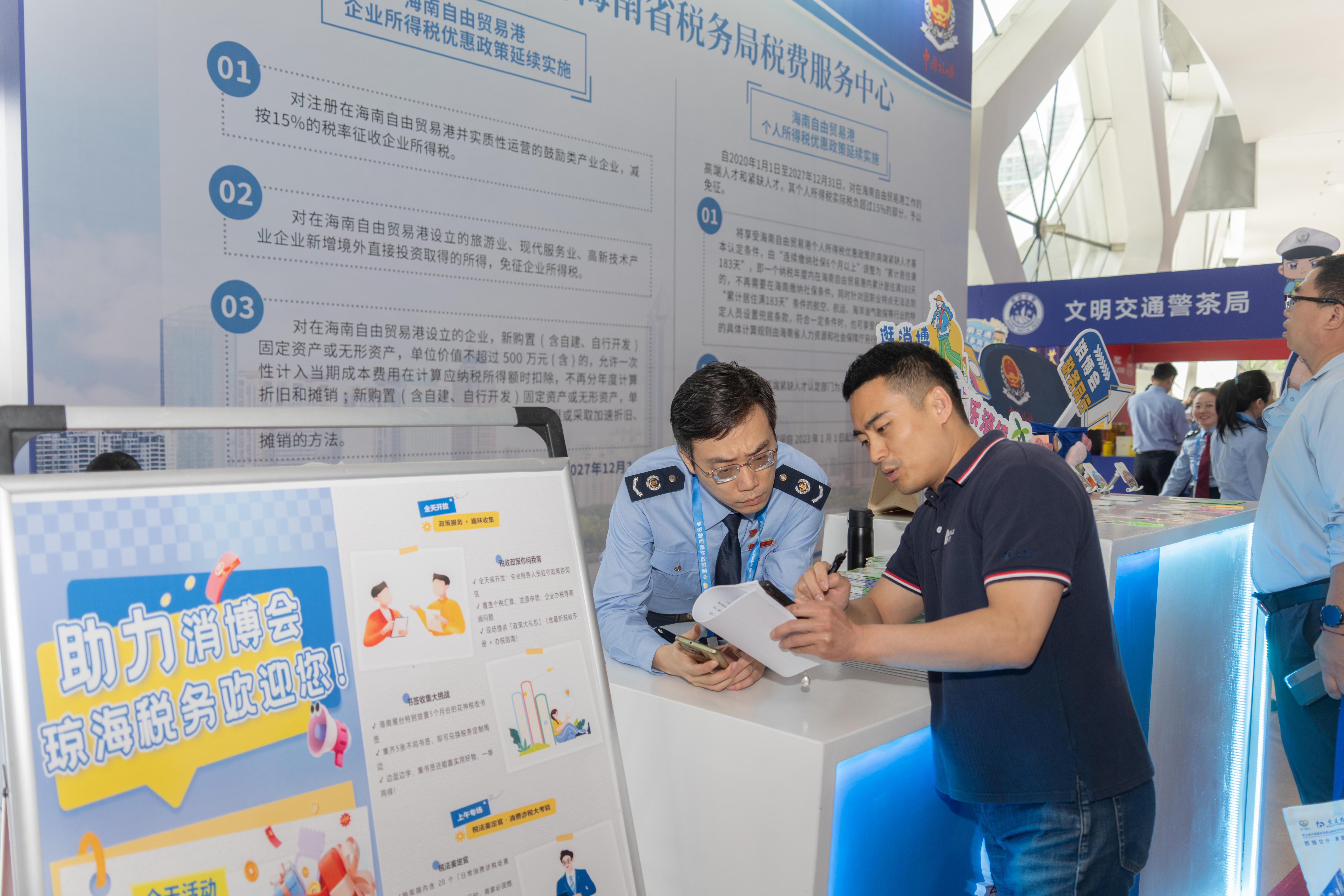 稅務(wù)服務(wù)臺(tái)工作人員向記者介紹服務(wù)參展外商的具體舉措。人民網(wǎng)記者 許崢攝
