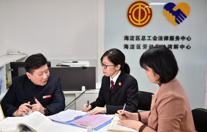 2025年3月6日，在北京市海淀區(qū)總工會勞動爭議調(diào)解中心，海淀區(qū)人民法院法官王琰（中）與該中心工作人員就糾紛化解情況進行溝通。新華社記者 趙婷婷 攝