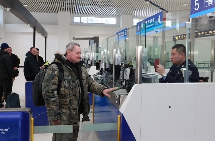 2024年12月10日，在黑河公路口岸旅檢大廳，黑河出入境邊防檢查站民警為首班次客車入境旅客辦理邊檢通關(guān)手續(xù)。當(dāng)日，中國(guó)黑河公路口岸—俄羅斯卡尼庫(kù)爾干公路口岸旅客運(yùn)輸正式開通。新華社發(fā)（劉松攝）